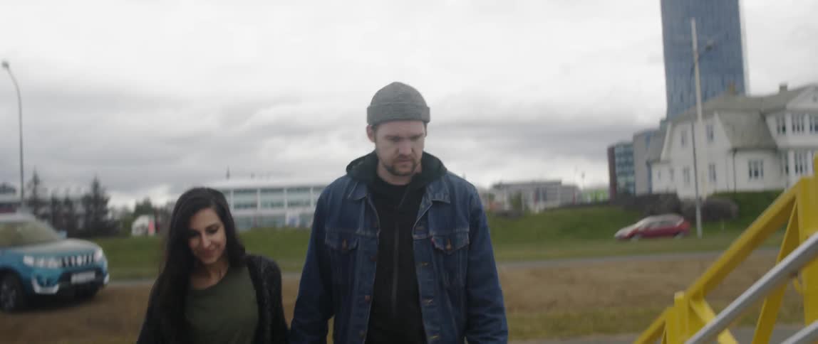 A man and woman hold hands and walk up the steps