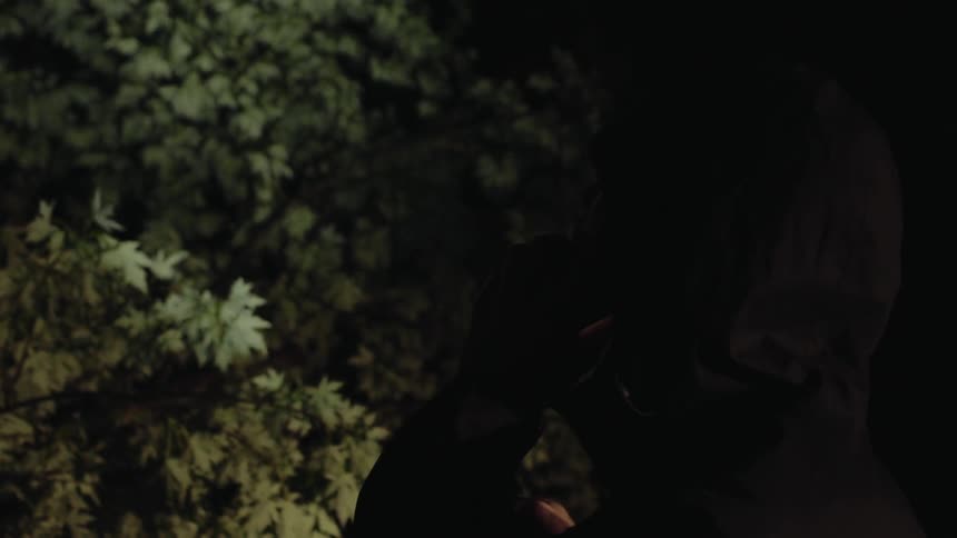 A man in a hood is talking on a phone