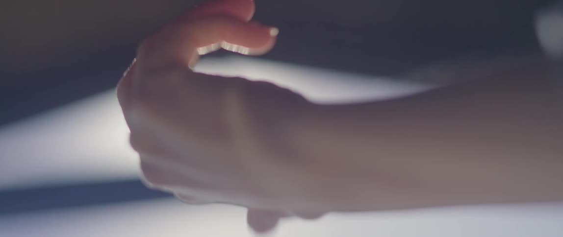 Woman moves her hand under a bright light