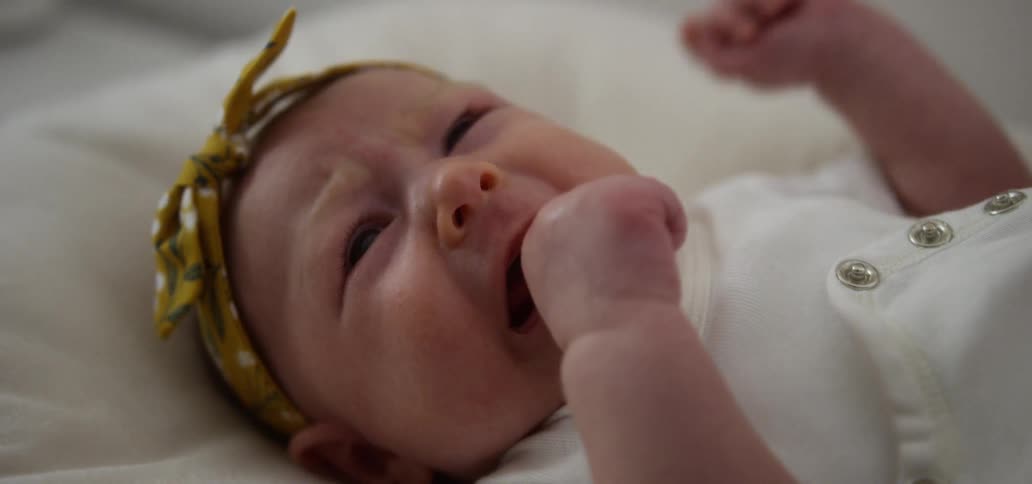 A baby is crying in the bed