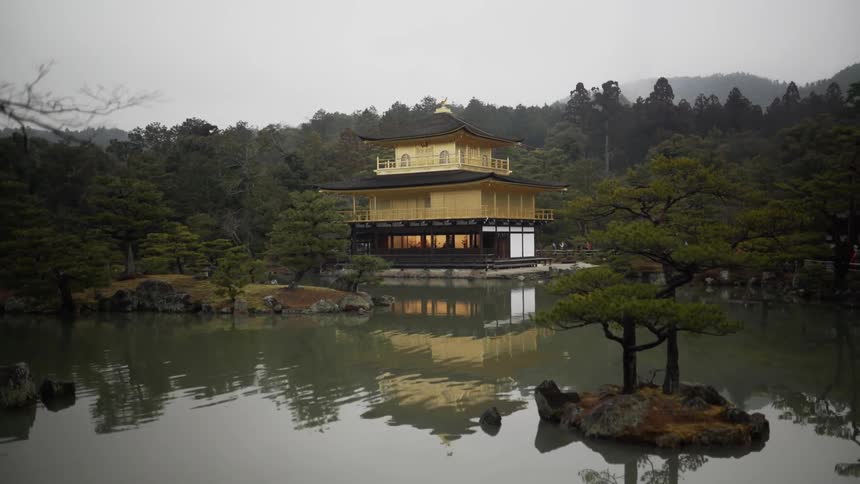 A golden pavilion sits on the edge of the water