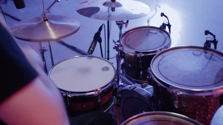 Lights flash while a man plays drums