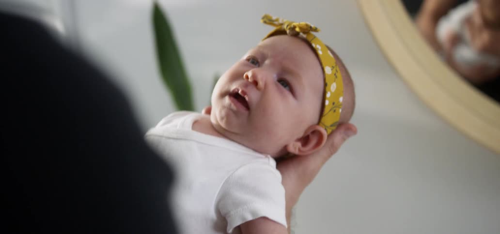 A man holds a young baby in his hand