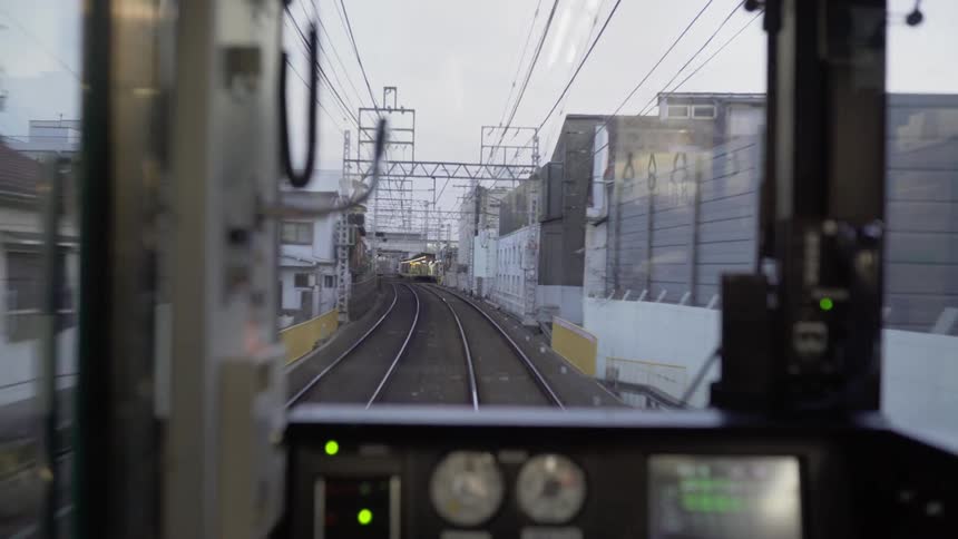 The view out the back of a train as it moves along the track through a town