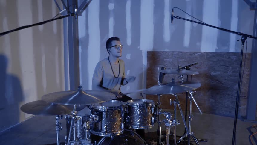 Man playing drums at night in a garage