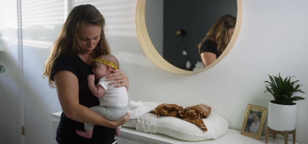 A woman bounces a baby in her arms