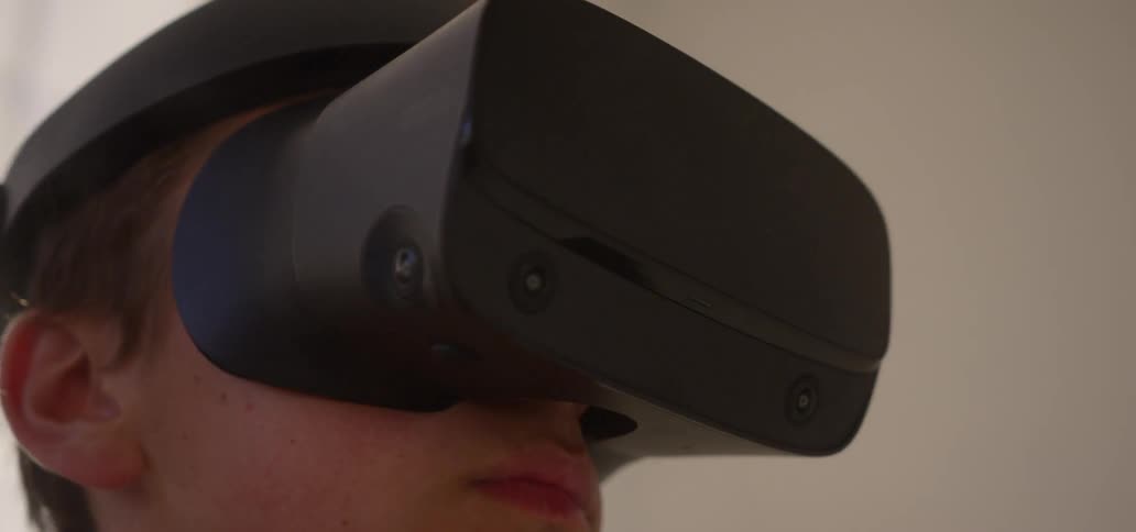A young man uses a vr headset in an empty room