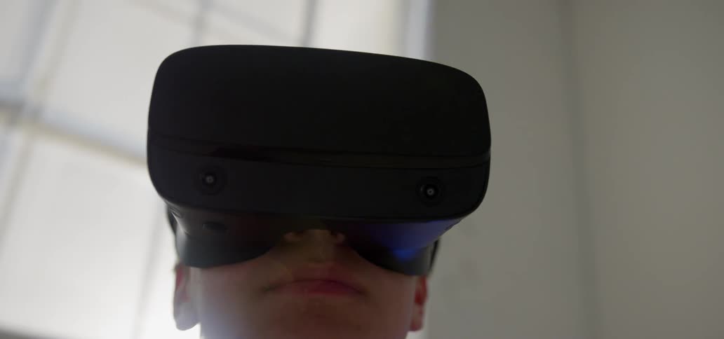 The man is looking around with a virtual reality headset