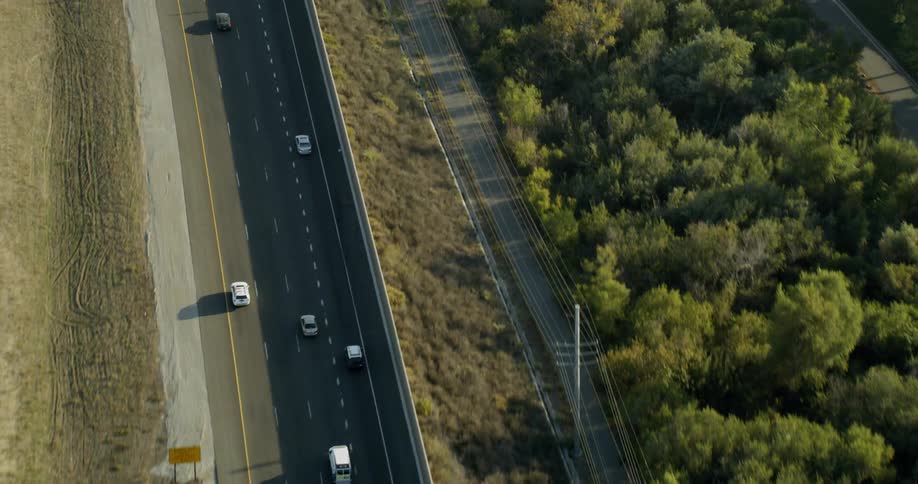 Vehicles drive down a highway in a country setting