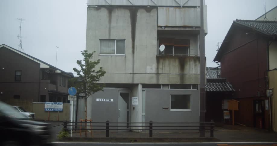 A car drives by a city building