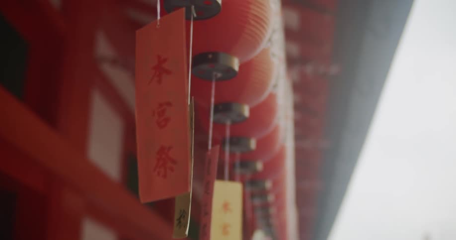 Colorful tags hang from strings outside a red building