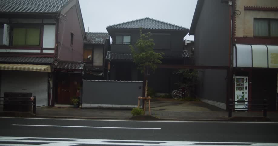 Cars pass by the homes on the street