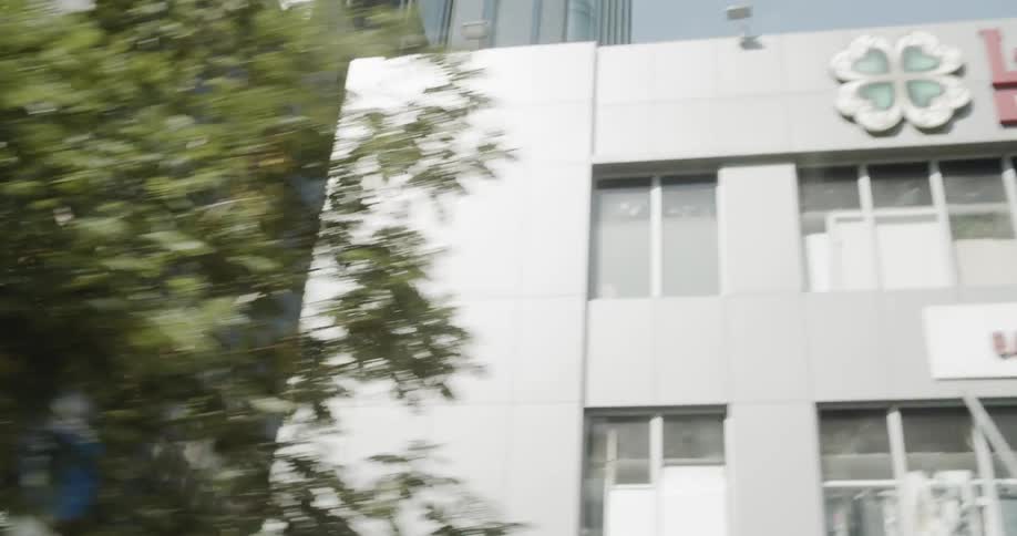Tall buildings with many windows sit near the trees