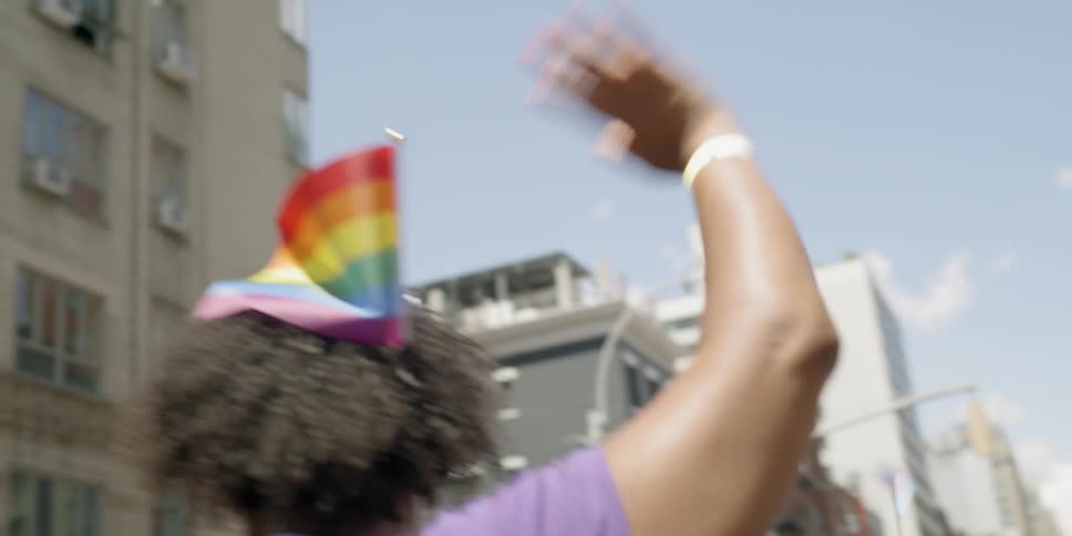 A woman waves her hand marching in a parade