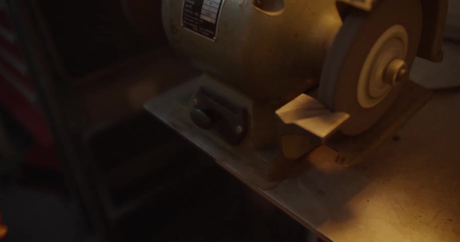 Arm wearing a bracelet pushes a button on a sander