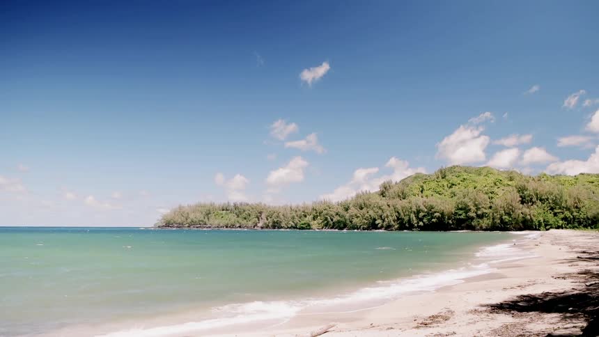 The blue waters crash against the sand