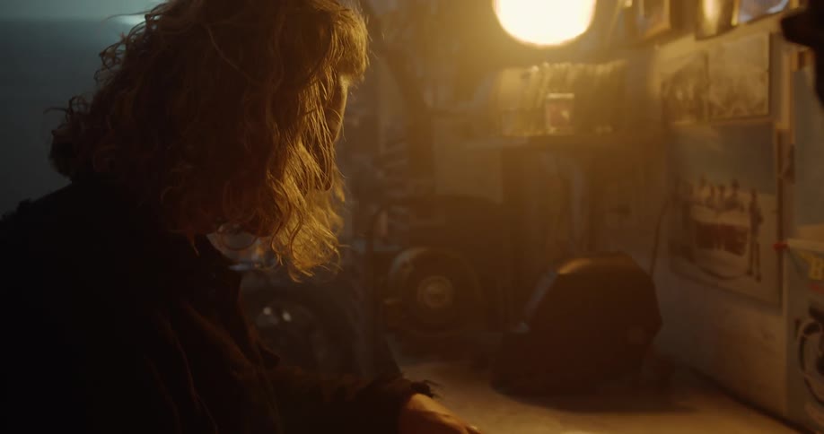 A man is working in a dark garage