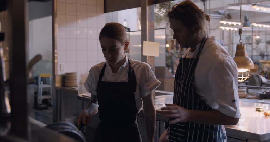 Two chefs work in a restaurant kitchen