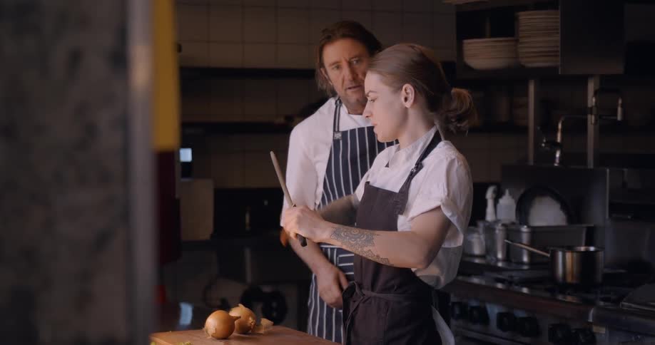 Two chefs are working in a restaurant kitchen in daylight