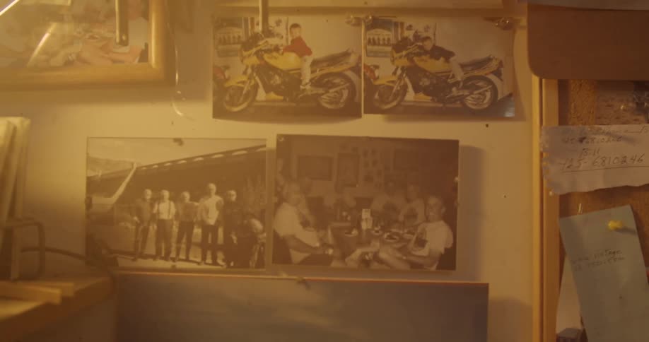 Photographs and a cork board hang on a wall