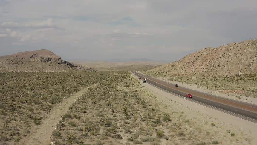 Vehicles travel down the highway under a cloudy sky