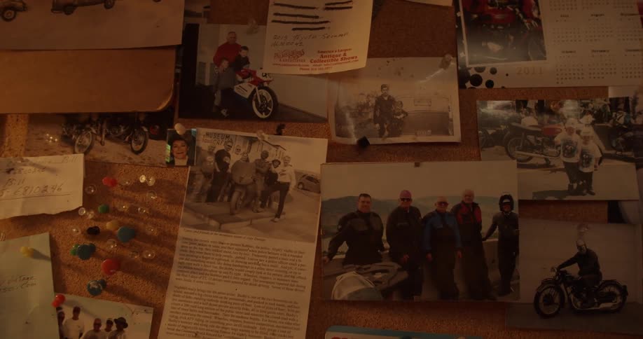 Photographs hang on a cork board