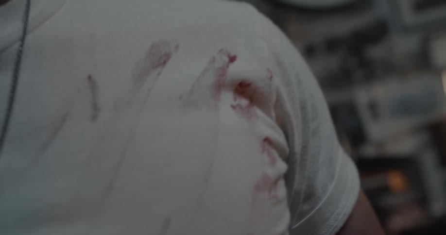 A man wipes his dirty hand on his shirt