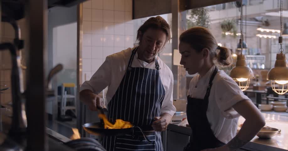 Two people talk in the restaurant kitchen