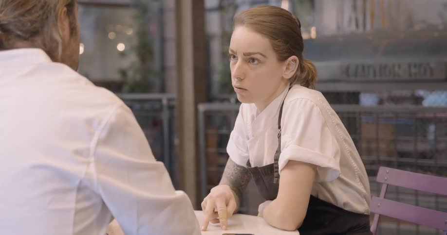 A woman with an apron is talking
