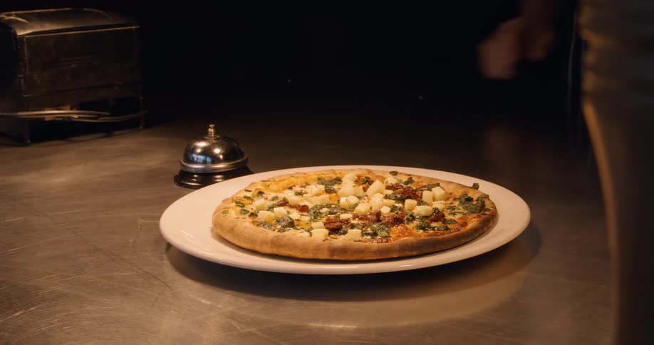 A person puts a pizza on the table