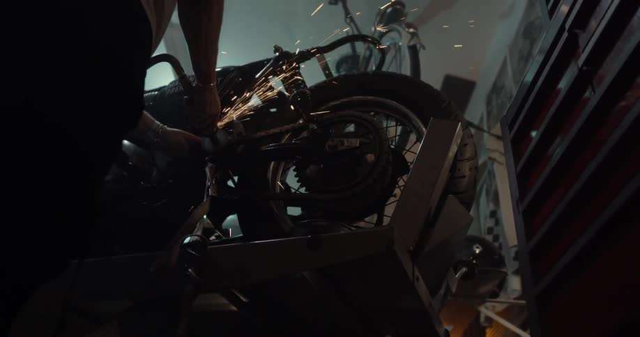 Sparks fly as a person works on a motorcycle