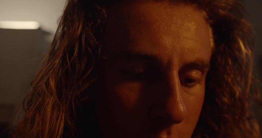 A man is looking down in a dark room