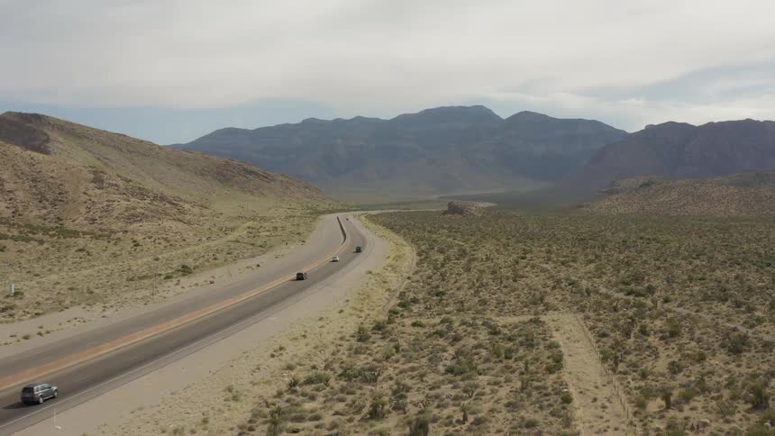 Cars travel on a desert road on a sunny day
