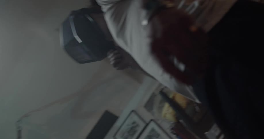A man is pulling down the visor on his helmet while inside a garage
