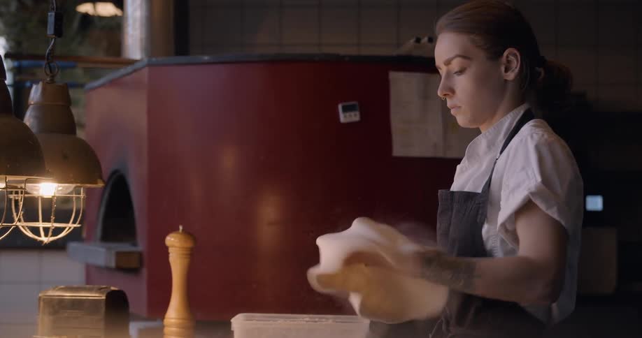 A chef makes pizza dough in a kitchen
