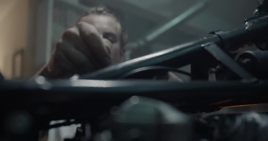 A man works on a motorcycle in a garage