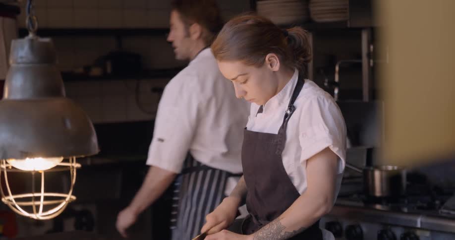 A chef chops food in the kitchen