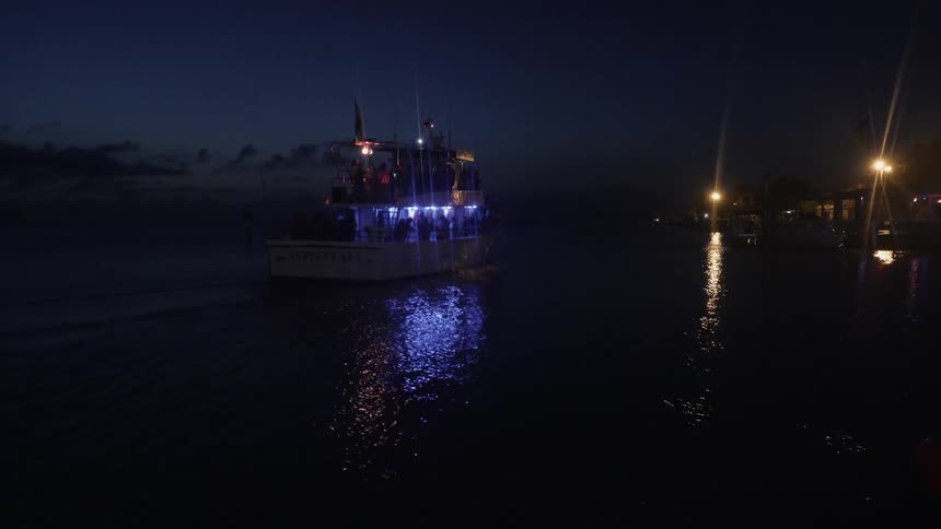 A boat floats on a lake in the dark