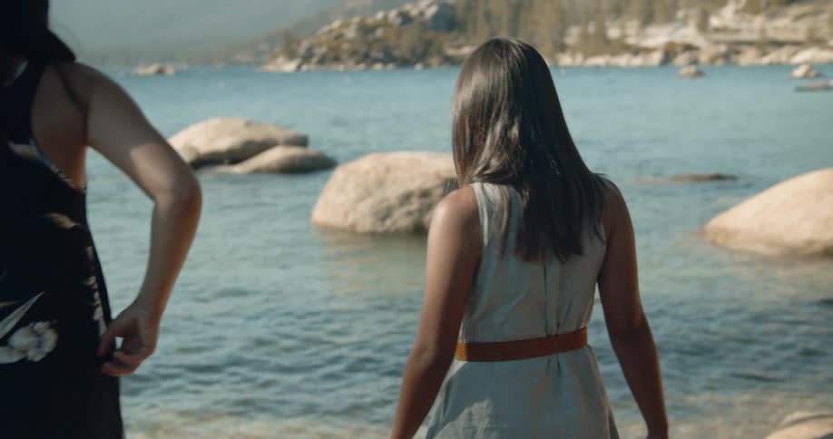 Woman walks down to the water's edge