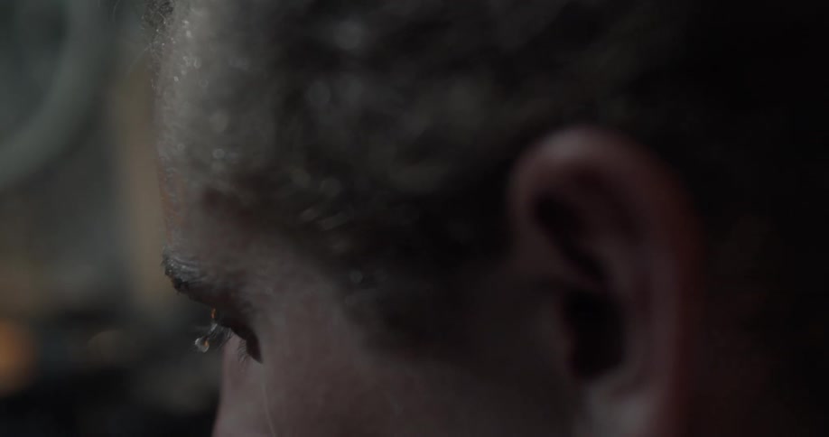 The man is looking down as he sweats