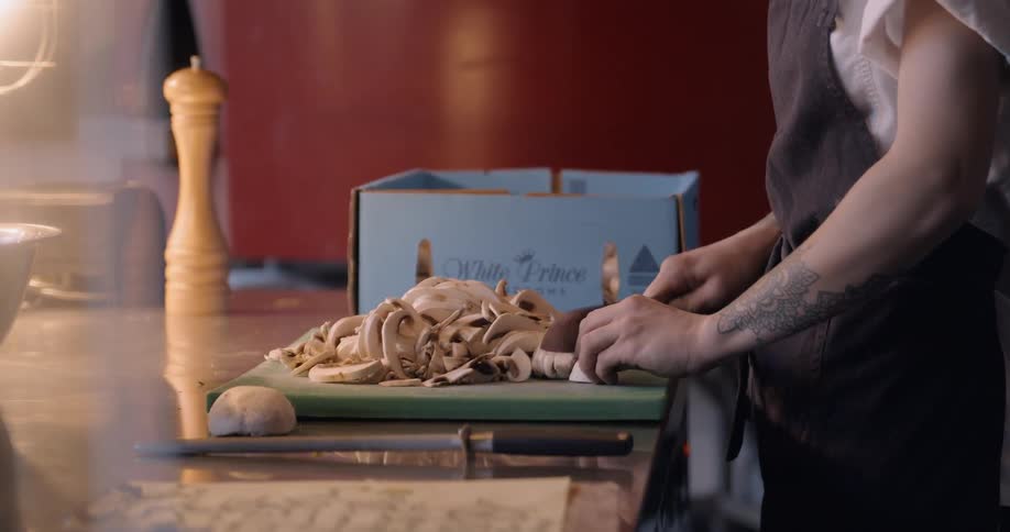 A woman is cutting mushrooms