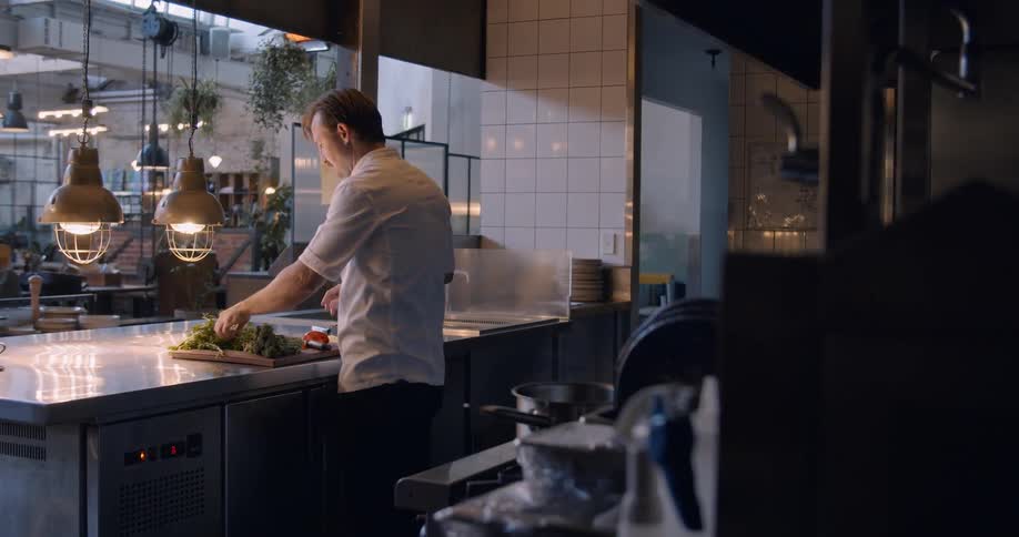 A man cuts vegetables in the kitchen