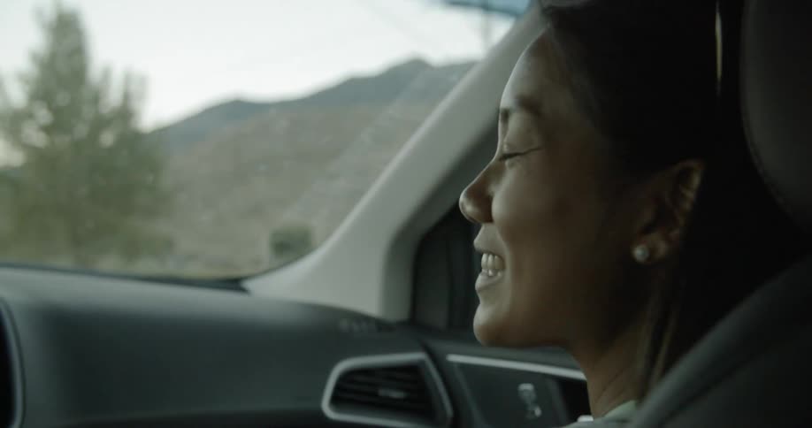 A woman is talking as she rides in the vehicle
