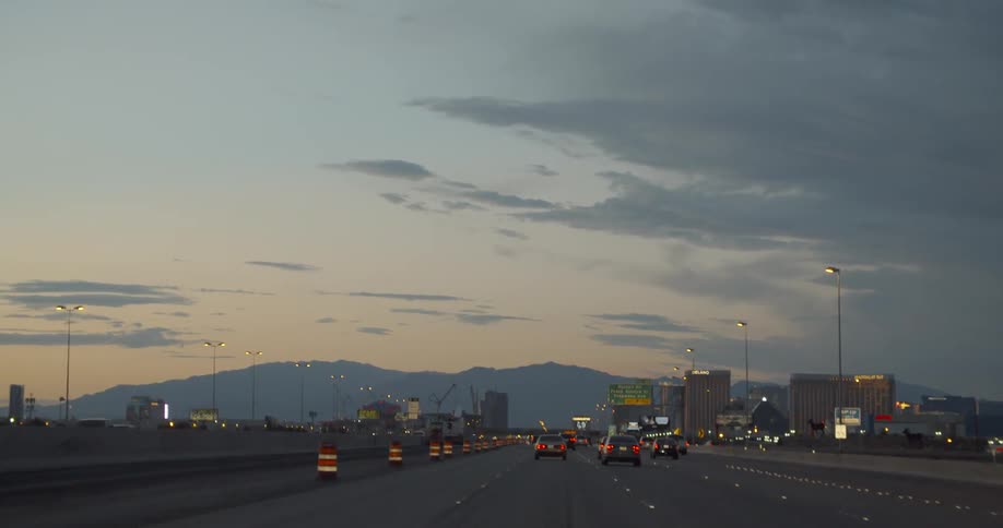 Cars drive on a city highway at dawn