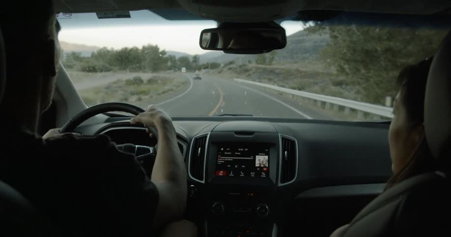 Man and woman are traveling in car on country highway