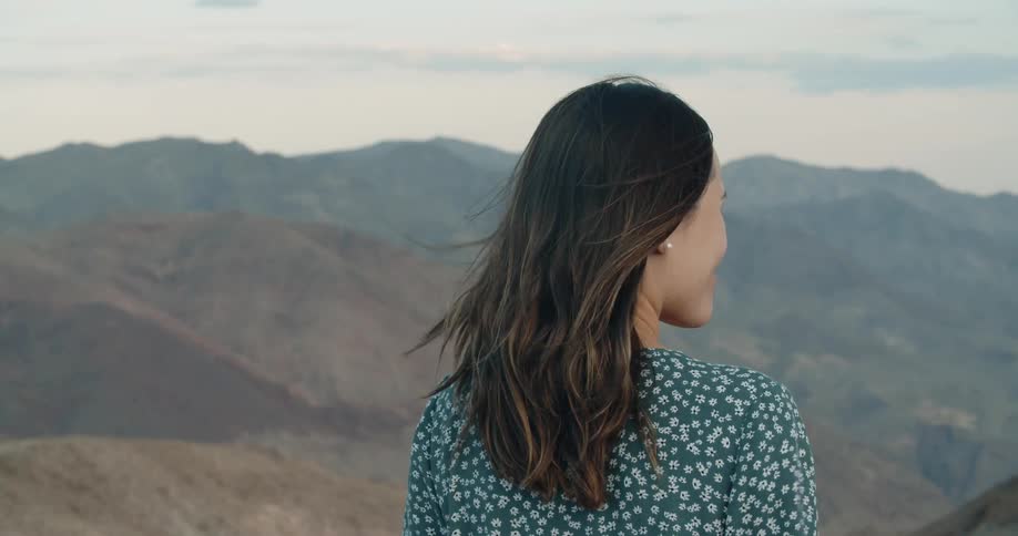 Woman takes in view of mountain skyline