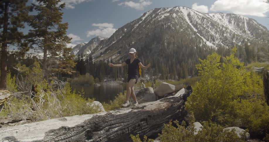 A woman balances over a long log