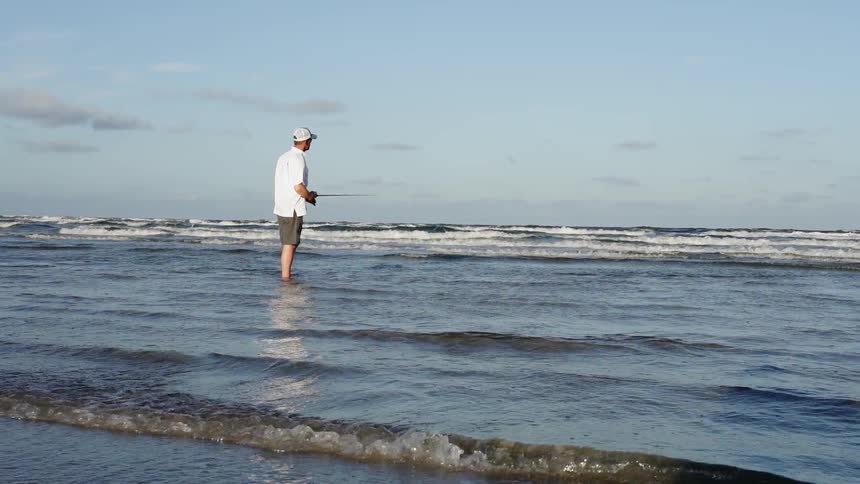 A man fishes on a beach