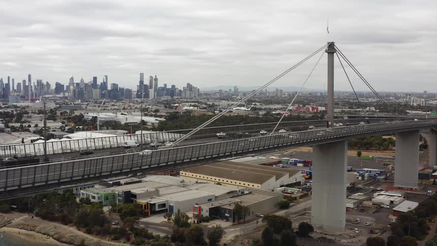 Cars drive along highway bridge towards Melbourne