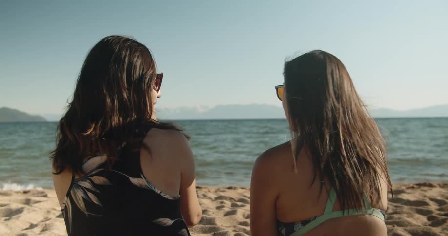 Two women talk on the beach
